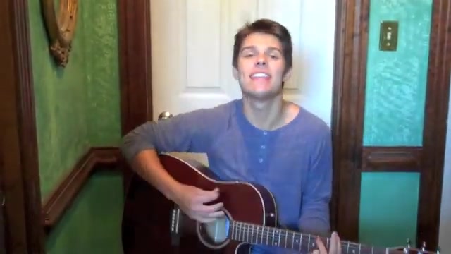 Cole in a henley shirt singing Dark Skinned Beauty with his acoustic guitar