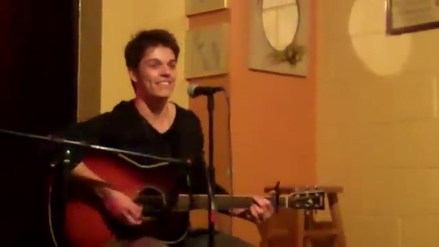 Cole smiling on stage at a Ventura Boulevard venue, performing Hideaway