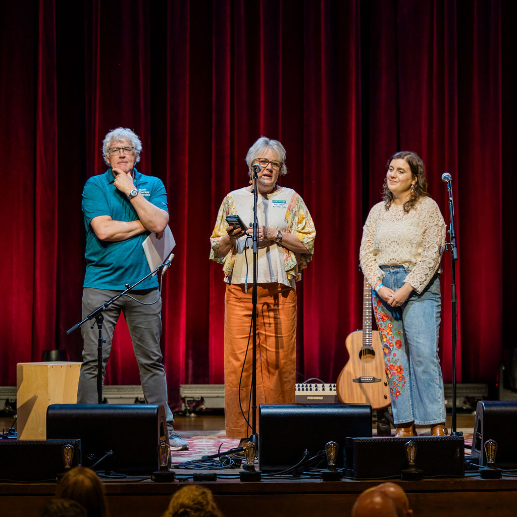 Speaker at the microphone, flanked by the night's hosts